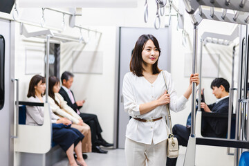 電車で移動をする若い女性