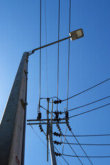 Fototapeta premium LED street lamps are mounted on tall concrete light poles with background of the sky.