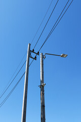 LED street lamps are mounted on tall concrete light poles with background of the sky.