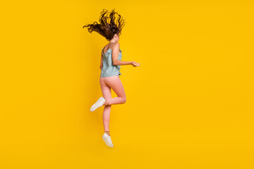 Fototapeta na wymiar Full length photo of cheerful young woman jump up fly hair good mood sale isolated on yellow color background