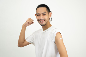 Happy Asian man showing strong arm and bandage after they get a vaccine.