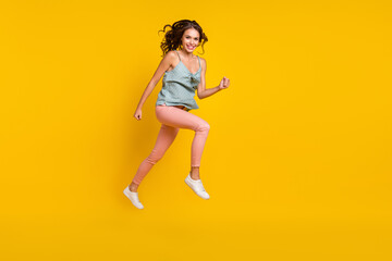 Fototapeta na wymiar Full size photo of positive cheerful woman jump up run look empty space sale news isolated on yellow color background