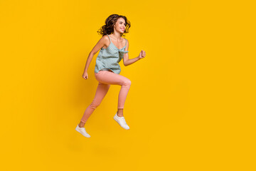 Full length photo of positive dreamy woman jump up run look empty space sale isolated on yellow color background