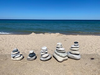 Cairns In Front of A Sandy Beach and Lake