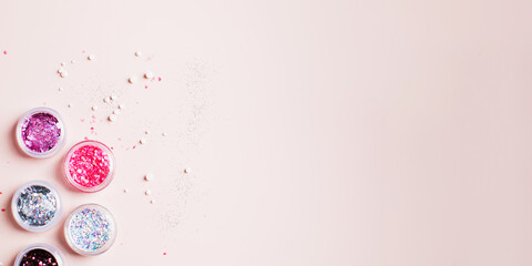 Banner. Shiny glitter powder for festive manicure Christmas party on pink background. Copy space