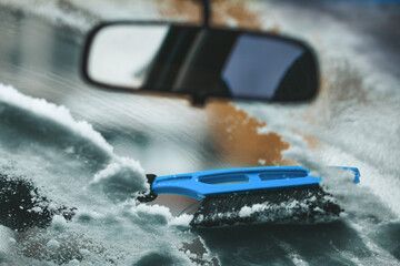 The brush removes snow from the car. Removing frost from the windshield.