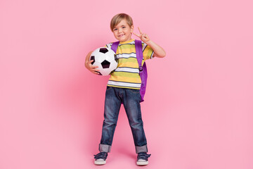 Full body photo of young little blonde boy backpack show v-sign wear jeans isolated on pink color background