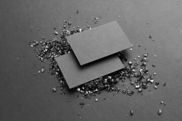 Business cards branding mockup template black moody feel. Blank isolated on a black background with black crystals to place your design. 