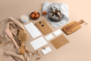 A blank branding set, featuring business cards, envelopes, cards, bread, eggs, flour, serving...