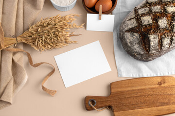 A blank card, with bread, eggs, flour, serving board, bakery branding mockup, empty space to...