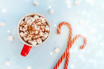 A mug of cocoa with marshmallows and a Christmas garland. A festive concept. Close up, top view