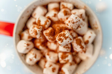 A mug of cocoa with marshmallows and a Christmas garland. A festive concept. Close up, top view