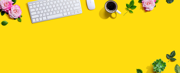 Computer keyboard and a mouse with pink roses - flat lay