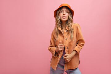 Portrait of stylish young caucasian lady with blond hair on light pink background. Confident girl...