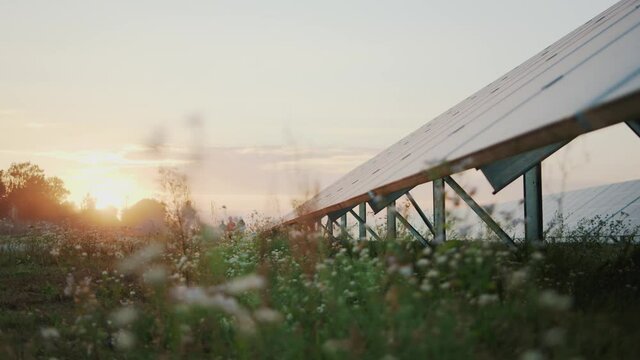 Beautiful sunset view of photovoltaic solar panels construction at eco-friendly sustainable factory. Global warming. Save nature. Environmental solutions.