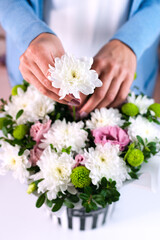 The florist girl makes a beautiful bouquet of white and pink flowers. Selective focus. Close-up.