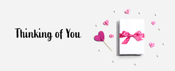 Thinking of you message with a gift box and paper hearts