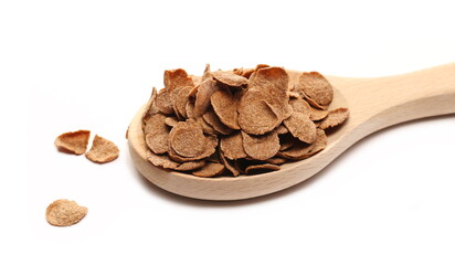 Crunchy corn flakes with cocoa, cereal, muesli pile in wooden spoon isolated on white 
