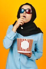 arab woman 3D glasses watching movies in the cinema yellow background