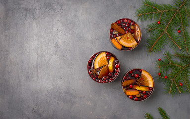 Glasses with traditional Christmas drink with cranberry on grey background with copy-space.