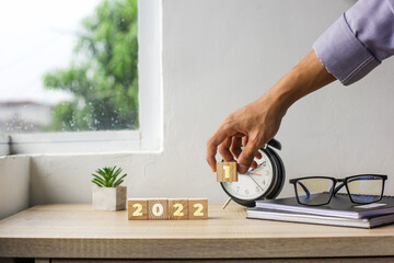 2022 inscription on wooden cube on office table. Year change concept from 2021 to 2022