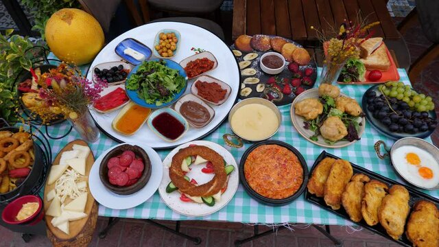 Choice of breakfast types at morning time in Turkish restaurant, traditional full set, simit sandwich, pan with fried food, pancakes with strawberry and banana, and so on