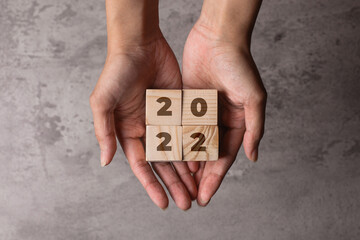 2022 inscription on wooden cube on hand