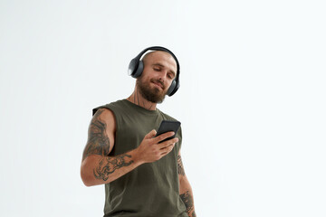Man listen music in earphones and use smartphone