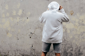 Back View Hoodie Mockup of a Man standing facing the wall