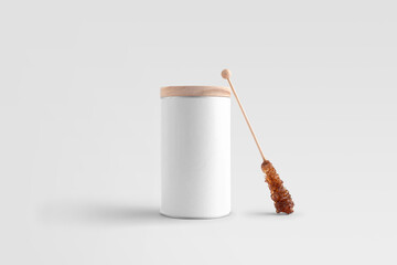 Blank tea container with a wooden lid, sugar stick, front view, on a white background, packaging mockup with empty space to display your branding design.