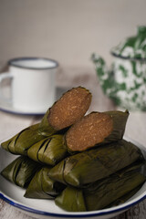 Cassava cake, known as katimus in West Java,Indonesia. Katimus made of compressed cassava cake in the form of a cylinder wrapped inside banana leaf then steamed. White is savory while brown is sweet