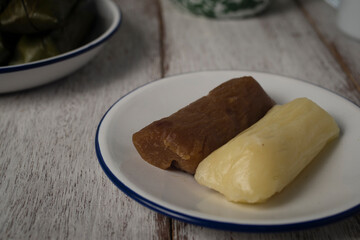 Cassava cake, known as katimus in West Java,Indonesia. Katimus made of compressed cassava cake in the form of a cylinder wrapped inside banana leaf then steamed. White is savory while brown is sweet