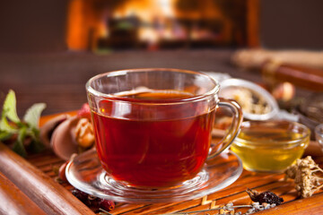 Cup of herbal mint tea with dry herbs on the tray.