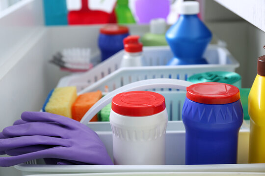 Different cleaning supplies in open drawer, closeup