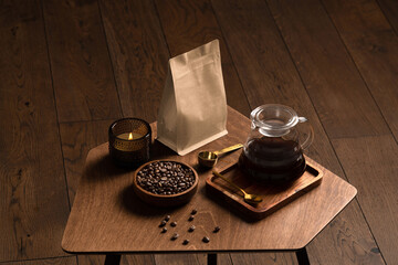 Obraz na płótnie Canvas Blank coffee packaging on a wooden table, with pot, coffee seeds bowl, on a wooden background, coffee packaging mockup with empty space to display your branding design.
