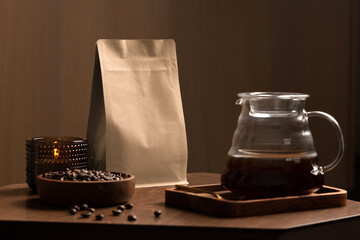 Blank coffee packaging on a wooden table, with pot, coffee seeds bowl, on a wooden background, coffee packaging mockup with empty space to display your branding design.