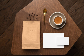 Blank coffee packaging on a wooden table, with empty cards, copper spoon, cup with coffee on a wooden background, coffee packaging mockup with empty space to display your branding design.