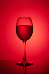 a glass of red wine on a red background