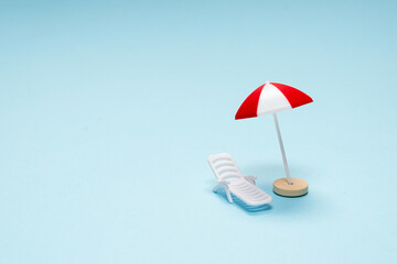 Travel concept. Sun lounger, red umbrella on a blue background.