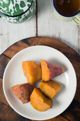 Steamed sweet potato, healthy snack for tea or coffee time and also brunch. Picture in top view or flatlay on wooden board and white background