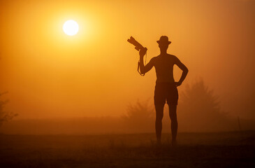 Man with a camera at sunset in a sandstorm