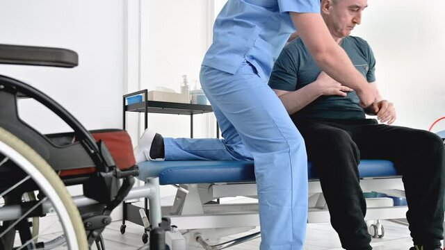 Man with disability doing recovery exercise with dumbbell. Disabled handicapped person in recovery support therapy physiotherapy healthcare system. High quality 4k footage