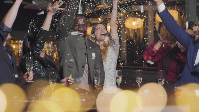 Wide Shot of Friends Celebrating New Year's Eve with Confetti