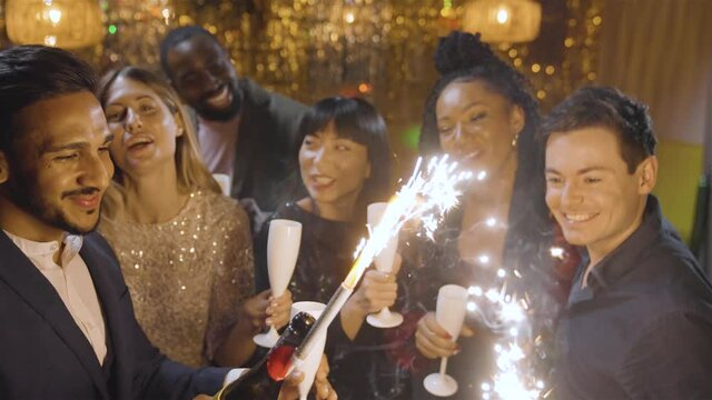 High Angle Shot of Group of Friends Celebrating New Years Eve with Champagne Sparklers
