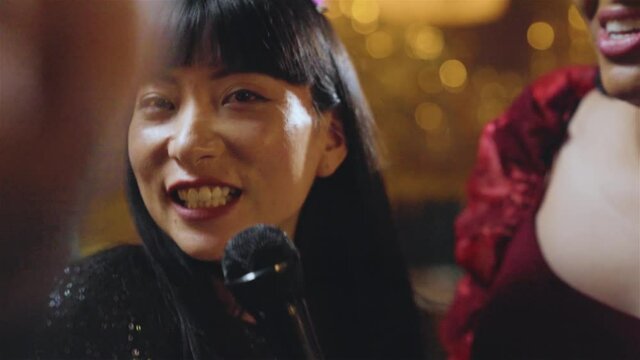 Tracking Shot of Woman Singing In Karaoke Bar with Her Friends