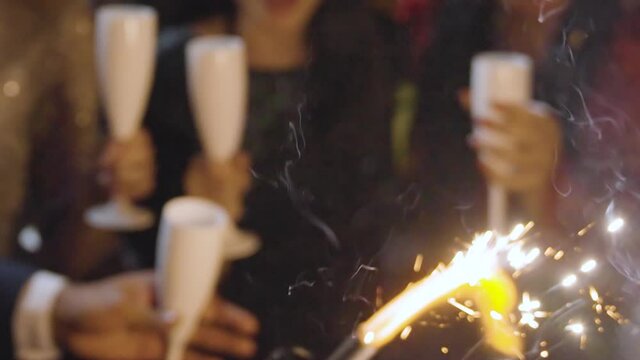 Close Up of Friends Celebrating New Years Eve with Champagne Sparklers