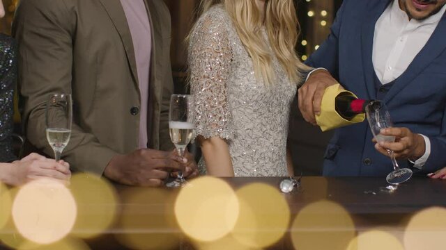 Mid Section Friends Pouring Champagne During New Years Celebrations