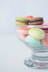 Artificial mini French macarons with various colors on glass isolated on white 