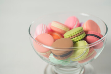 Artificial mini French macarons with various colors on glass isolated on white 