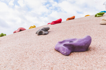 Fototapeta na wymiar children's climbing wall rock simulator trainer colored hooks